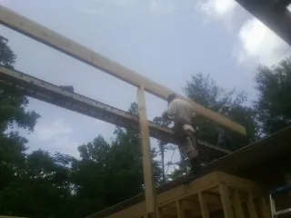 Carpenter setting a ridge beam over a new addition frame — Ice Dam Removal by Roofing Brothers in Xenia