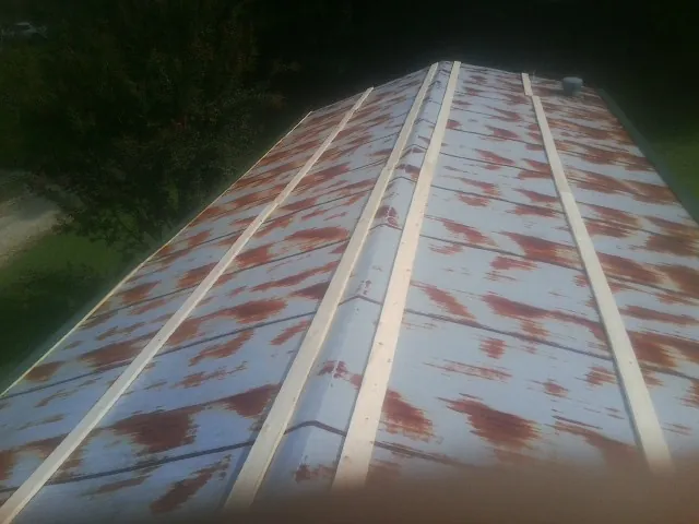 Rusted metal roof panels with new wood purlins before replacement — Storm Damage Roof Repair in Xenia by Roofing Brothers