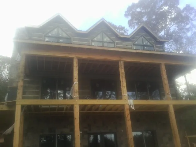Dormers and porch framing on a large log home under construction — Roof Coating work by our crew in Xenia
