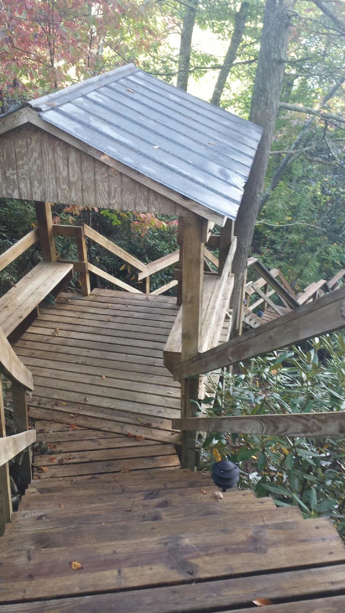 Metal roofed shelter over wooden steps on a wooded walkway — Skylight Repair & Installation work by our crew in Xenia