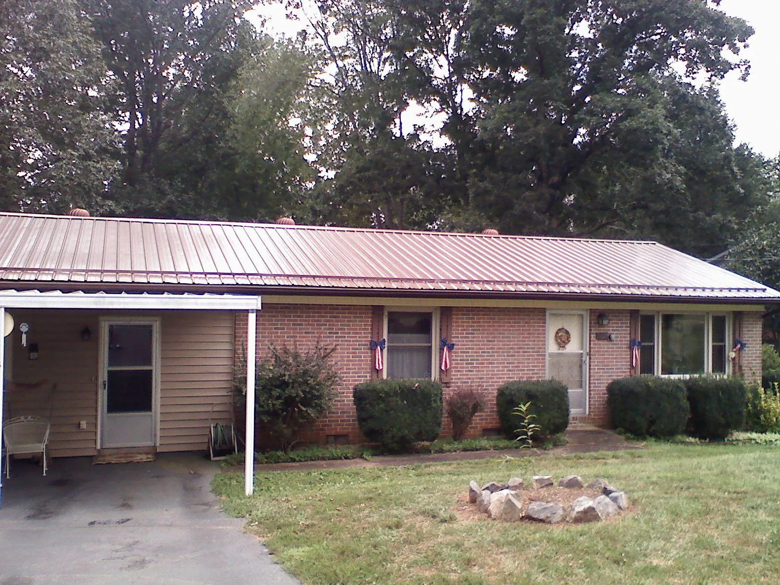 Bronze metal roof and carport on a brick ranch home — Roof Repair work by our crew in Xenia